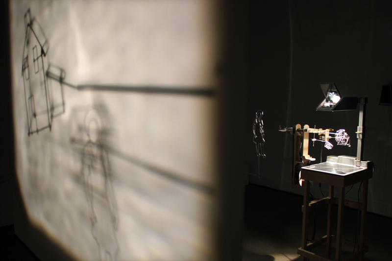 projections,installation cinétique et sonore de manon labrecque,mécanismes,silhouette,maison,chien,enfance,chute perpétuelle,lanterne magique